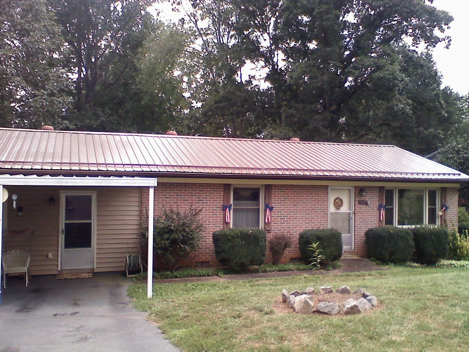 Bronze metal roof and carport on a brick ranch home — Roof Repair work by our crew in Baltic
